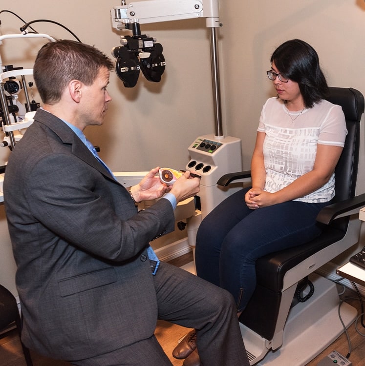 optometrist showing an eye model to a patient