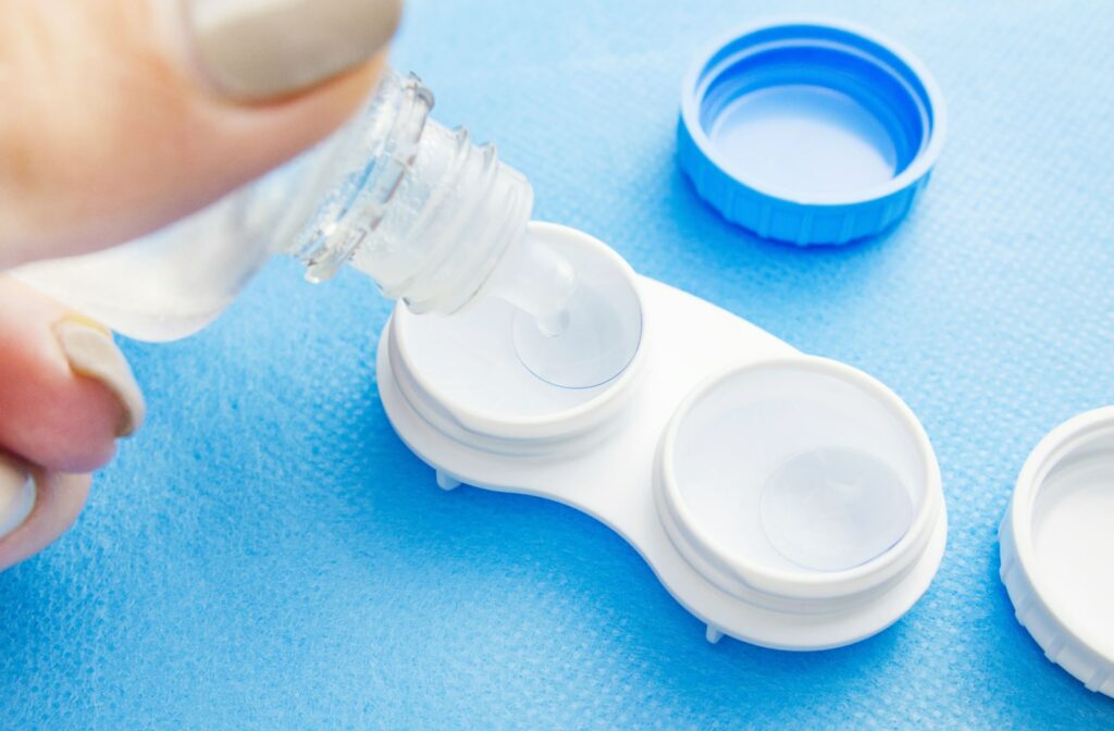 A woman pours contact lens solution in her contact lens case.