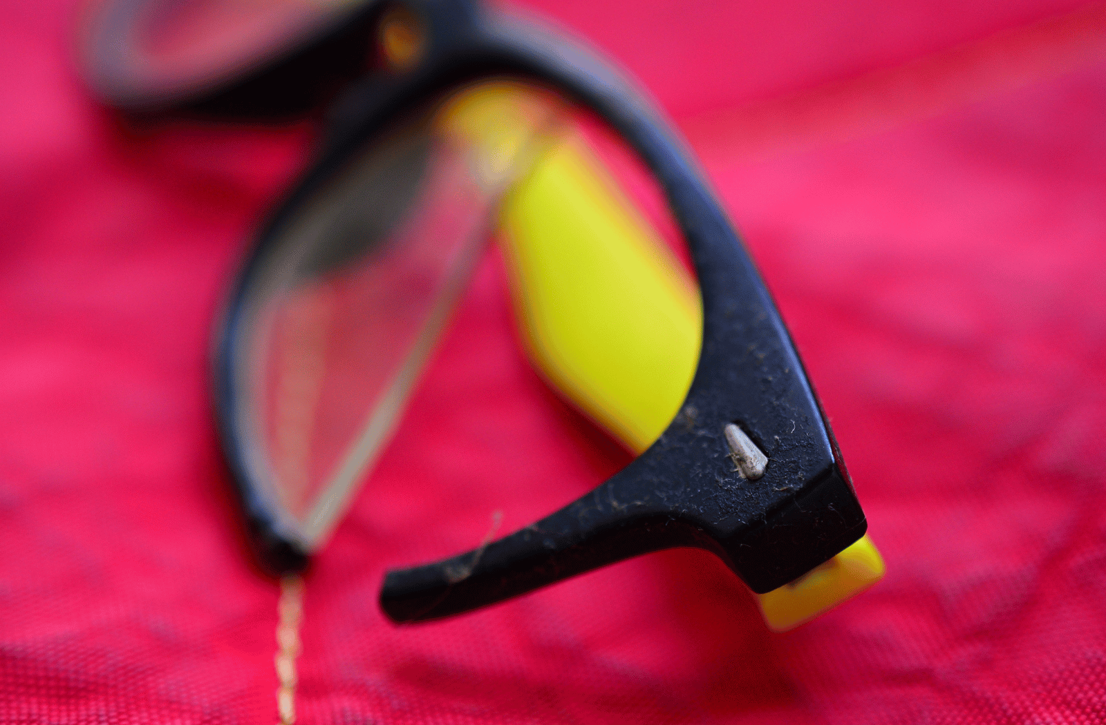 A pair of black and yellow glasses with a broken frame