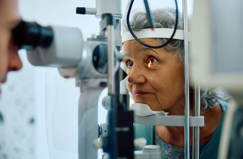 A patient has their eye examined for AMD by an optometrist using a slit lamp.