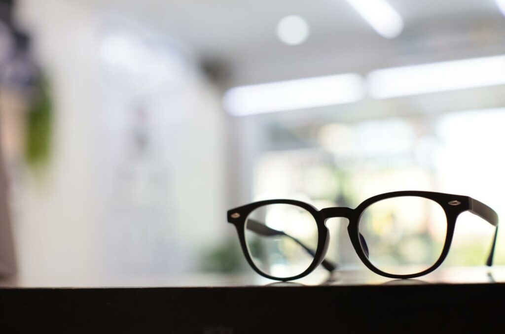 A pair of progressive eyeglasses sitting on the counter in an optometrist's office.