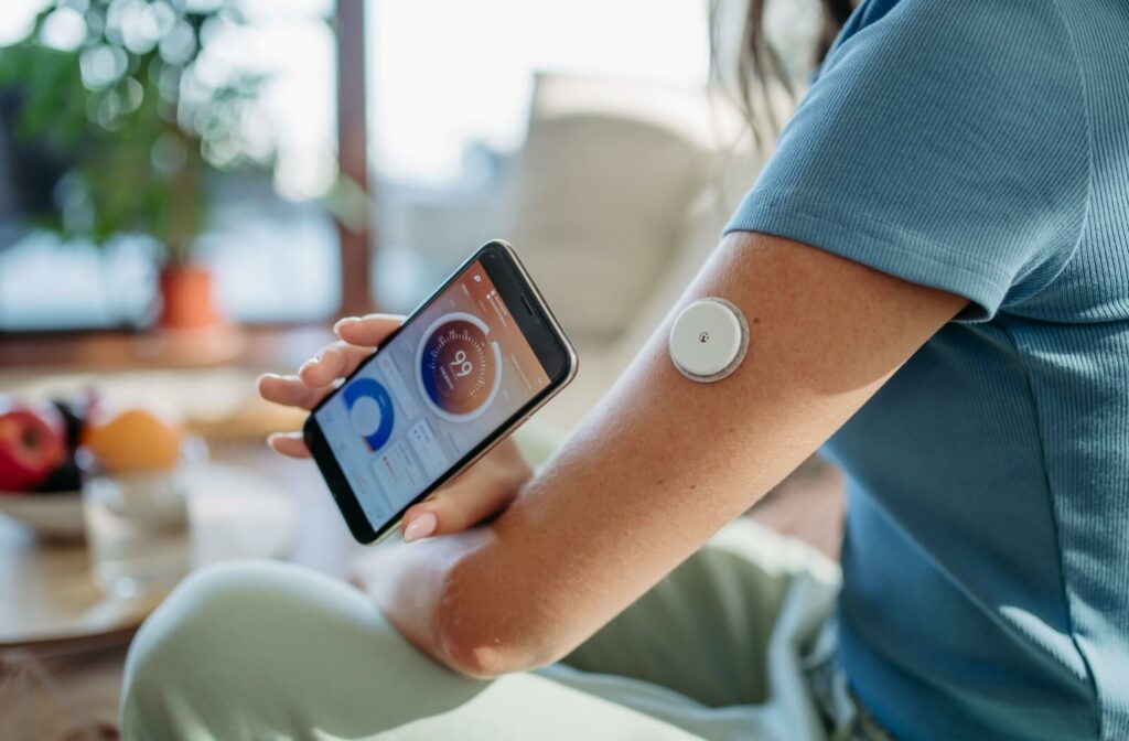 A person with diabetes checking their glucose monitor.